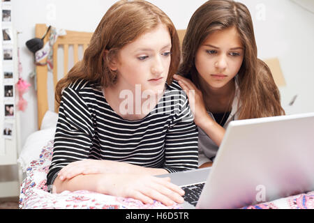 Ragazza con un amico di essere vittima di bullismo On Line Foto Stock