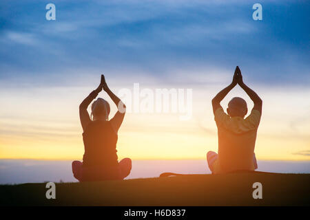 Silhouette di giovane facendo yoga. Foto Stock