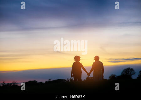 Silhouette di giovane tenendo le mani. Foto Stock