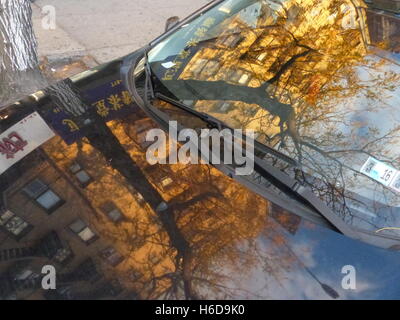 Albero e appartamento edificio riflettendo in auto del parabrezza Foto Stock