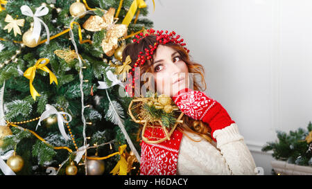 Ritratto di una ragazza carina accanto a un albero di Natale. L'atmosfera di festa. Foto Stock