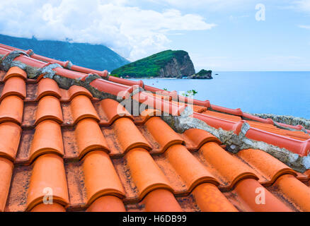 La vista sul Sveti Nikola Island oltre il tetto di tegole della cittadella, Budva, Montenegro. Foto Stock