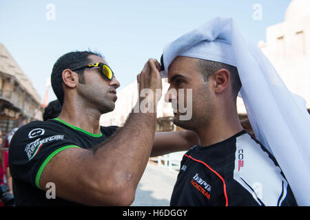 Souq Waqif Doha, in Qatar. 27 ott 2016. Saeed Al adjustes Sulati i copricapo di Xavi Fores durante una visita al Souq Waqif a Doha Credito: Tom Morgan/Alamy Live News Foto Stock