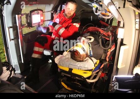 Suederstapel, Germania. 29 ott 2016. Medico Holger Harbs trattare un extra che rappresenta un gravemente ferito paziente in elicottero di salvataggio "Christoph 42' dal DRF air rescue stazionati a Rendsburg durante un allarme seminatrice con il dipartimento dei vigili del fuoco e servizi di soccorso sul campo sportivo di Suederstapel, Germania, 29 ottobre 2016. La CE 145 cura intensiva elicottero da elicotteri Airbus Deutschland GmbH è la sostituzione delle attuali BK 117. Foto: Wolfgang Runge/dpa/Alamy Live News Foto Stock