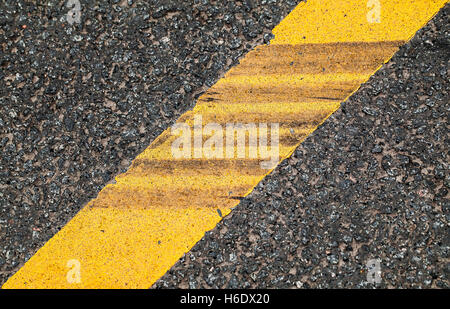 Giallo linea divisoria con tracce di pneumatici su di esso, autostrada la segnaletica stradale. Abstract background di trasporto Foto Stock