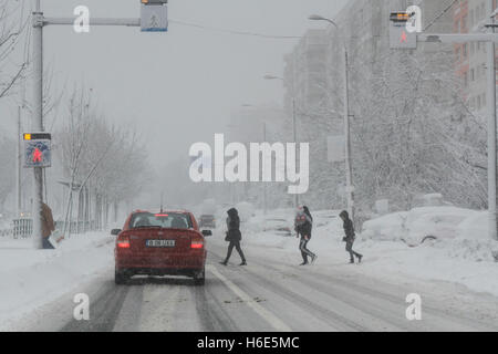 Bucarest, Romania, 17 Gennaio 2016: pedoni stanno attraversando la strada durante una nevicata a Bucarest. Foto Stock