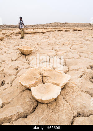 La gente camminare attraverso minerali formazioni del terreno intorno al lago di zolfo Dallol in depressione di Danakil, Etiopia. Foto Stock