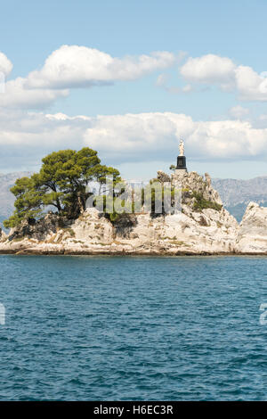 Le rocce della parete del porto e una statua della Madonna nel porto di Trpanj Croazia Foto Stock