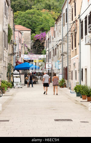 I turisti a piedi in strada tra i vecchi edifici in pietra e negozi a Ston Croazia Foto Stock