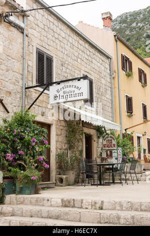 Il ristorante di pesce e frutti di mare in Stagnum Ston Croazia che mostra i tavoli fuori e la vite entrata coperta Foto Stock