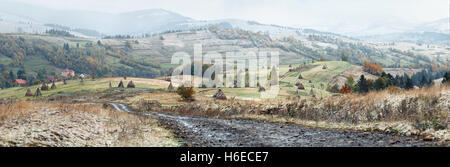 Prima neve in autunno. Nevicata nel villaggio di montagna. La neve su un albero verde. Foto Stock