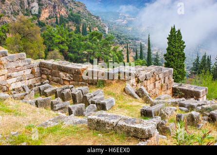 La fondazione delle antiche costruzioni in Delphi area archeologica con la foresta di nebbia sullo sfondo, Grecia. Foto Stock