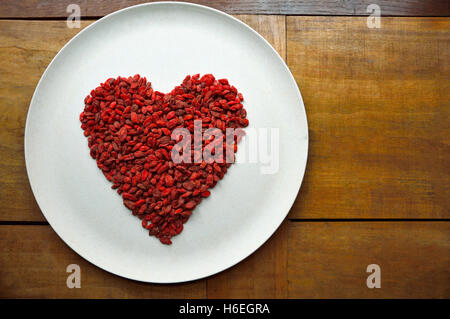 Cuore di goji bacche su una piastra Foto Stock