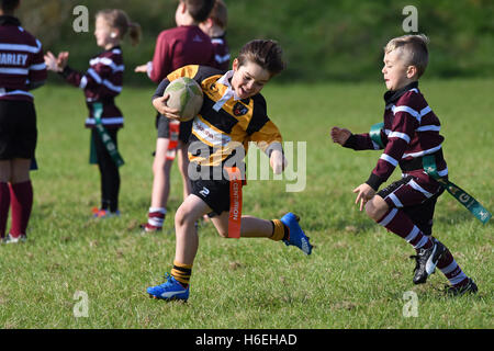 Ragazzo sorridente felice che gioca azione partita di rugby tag junior per bambini Regno Unito bambini bambini bambini sport attività sana sport ragazzi sport Foto Stock