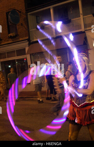 Ragazza giovane eseguendo con incandescente hula hoops sulla strada di notte Foto Stock