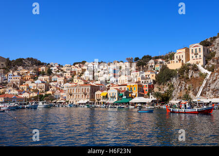 Symi island - case colorate e piccole imbarcazioni al cuore del villaggio Foto Stock