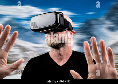 Uomo che indossa le cuffie VR e toccando qualcosa con le sue mani (montage) Foto Stock