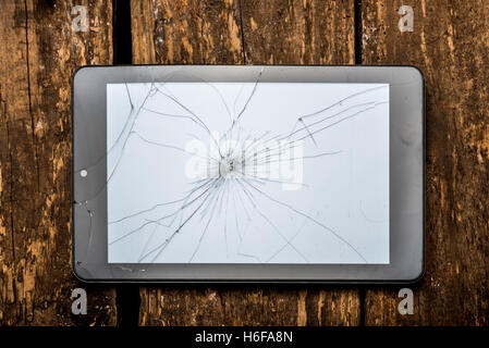 Tablet sul tavolo di legno con il vetro rotto Foto Stock