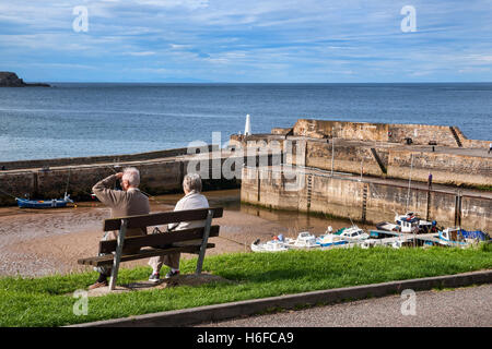 Coppia di anziani godendo di Cullen porto e la baia, Moray Firth, regione delle Highlands della Scozia Foto Stock