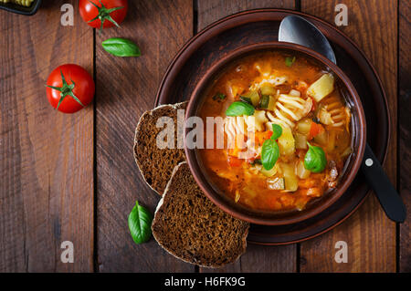Il Minestrone, italiano minestra di verdura con la pasta su un tavolo di legno. Vista superiore Foto Stock