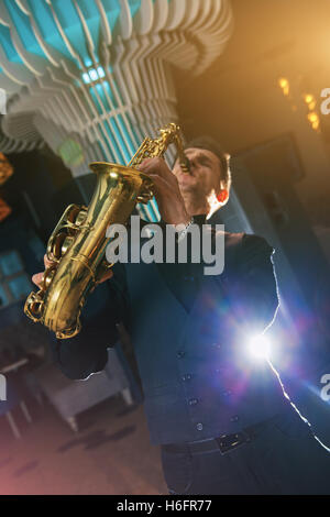 Giovane uomo suona uno strumento musicale sassofono Foto Stock