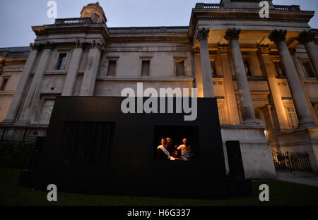 Membri della prestazione italiana troupe di quadri plastici ricreare Caravaggio la pittura di Salomè riceve la testa di Giovanni il Battista come una "vita" della pittura di fronte alla National Gallery in Trafalgar Square a Londra. Foto Stock