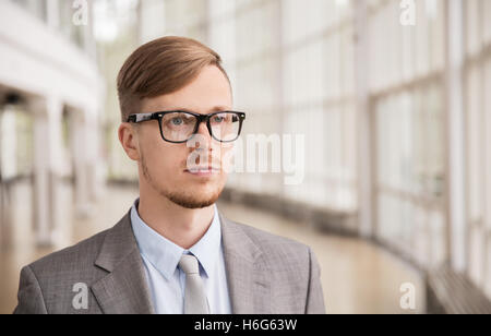 Giovane imprenditore della tuta e occhiali in ufficio Foto Stock