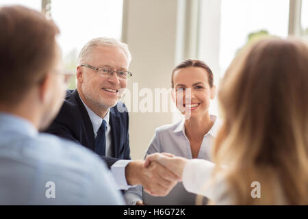 Imprenditore senior rendendo stretta di mano in ufficio Foto Stock