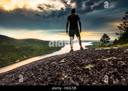 Drammatico colpo di un giovane uomo su una montagna si affacciano nel Parco Nazionale di Acadia, isola di Mount Desert, Maine. Foto Stock