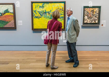 Un uomo e una donna a stare di fronte ad una pittura di discuterne in un museo. Foto Stock