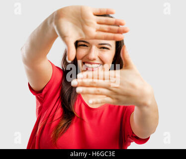 Ritratto di una bella donna incorniciare il viso tra le mani e sorridente Foto Stock