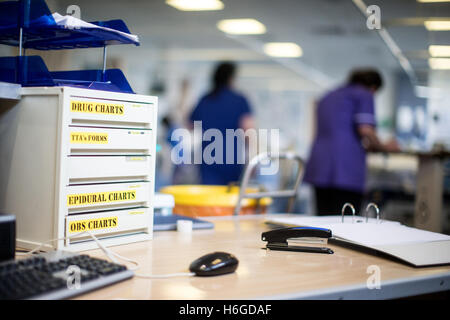 Foto di workstation che mostra i cassetti di farmaco in un ospedale con i pazienti e il personale in background Foto Stock