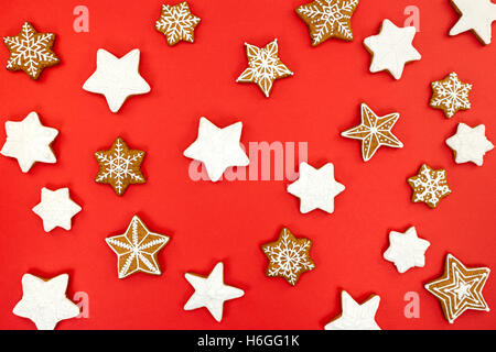 Il simbolo del fiocco di neve e a forma di stella di Natale gingerbread cookie su sfondo rosso Foto Stock