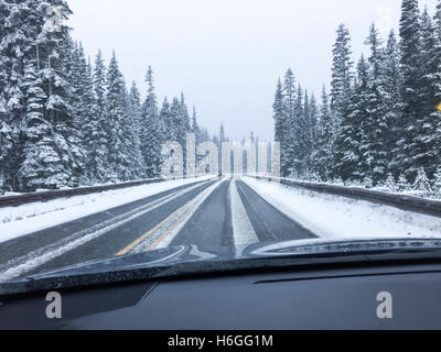 Conducente del punto di vista viewpoint guardando attraverso il parabrezza per auto di strada innevata in inverno la guida Foto Stock