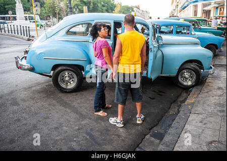 L'Avana, Cuba - Giugno 12, 2011: i passeggeri cubani attendere per immettere un americano classico taxi sul Prado nel centro di Avana. Foto Stock