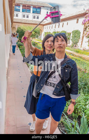 Un giovane adulto Asian giovane tenendo selfie, Alhambra di Granada, Spagna. Foto Stock