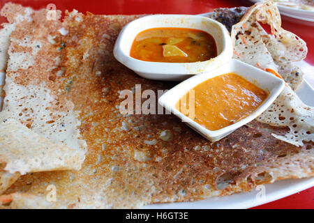 Rava dosa o Ravvattu o Rave Dose, è un Indiano crêpe dell India del Sud servire con curry e salsa di peperoncino Foto Stock