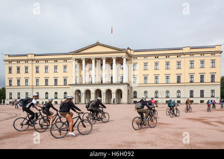 I ciclisti pedalando attraverso il Royal Palace, Det Kongelige Slott, Oslo, Norvegia Foto Stock