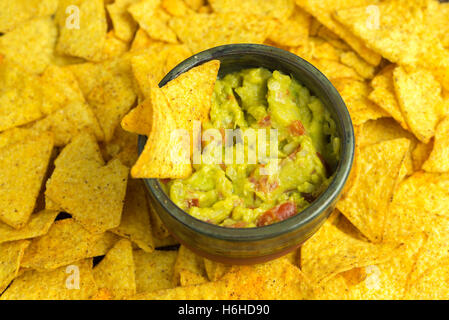 Guacamole in casa recipiente predisposto con tortilla chips e dintorni. Foto Stock