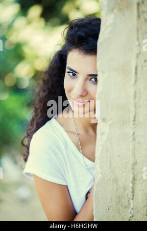 Bella ragazza appoggiata contro il muro sorridente Foto Stock