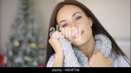 Sognante giovane donna snuggling nella sua sciarpa Foto Stock