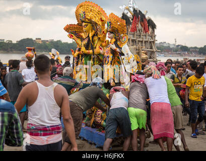 Gruppo di uomini spingere Durga idolo al fiume Gange per immersione a Babughat Kolkata, West Bengal, India. In cinque giorni Durga puja Foto Stock