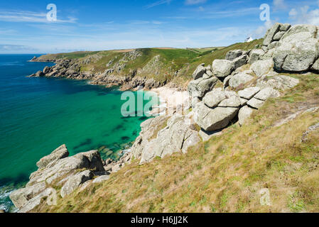 Il mare turchese, scogliere rocciose presso la luminosa sabbiosa Cappella Porth Beach sulla penisola di Penwith sulla costa meridionale della Cornovaglia, Inghilterra, Regno Unito in estate Foto Stock