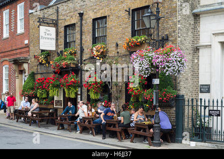 Persone sedute e di bere al di fuori dei locali dei due produttori di birra pub decorate con fiori di fioritura nelle vicinanze del castello di Windsor in un giorno di estate, REGNO UNITO Foto Stock