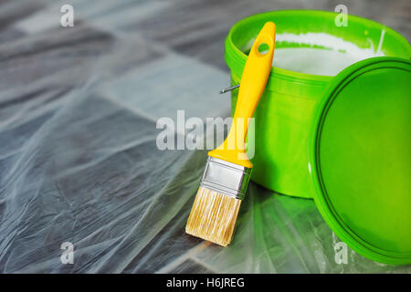 Vernice gialla spazzola e secchio verde sul pavimento, pronto per il lavoro domestico progetto e pareti redecoration Foto Stock