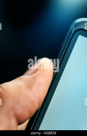 Sblocco di smart phone con il sensore di impronte digitali di scansione da vicino con il fuoco selettivo Foto Stock