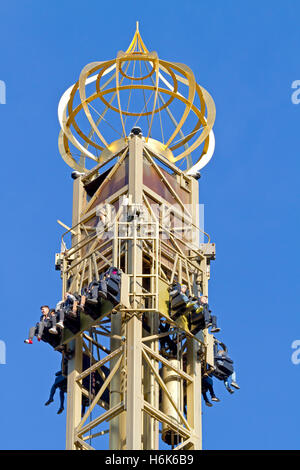 La parte superiore della torre Dorata, Det Gyldne Tårn, a 63 m di altezza di caduta della torre, persone in attesa di caduta libera. I Giardini di Tivoli, Copenaghen. Halloween stagione. Foto Stock