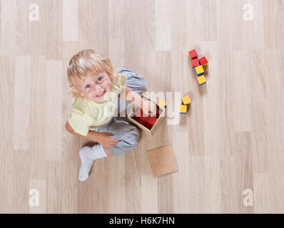 Kid giocando con i giocattoli sul piano vista superiore Foto Stock