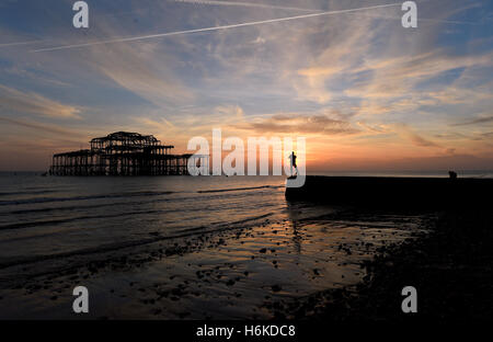 Brighton SUSSEX REGNO UNITO 30 Ottobre 2016 - Visitatori godere il bellissimo tramonto a un altro autunno extra bassa marea dal Molo Ovest di Brighton al tramonto questa sera come insolitamente mite meteo continua nel sud del Regno Unito Credito: Simon Dack/Alamy Live News Foto Stock