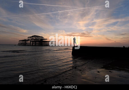 Brighton SUSSEX REGNO UNITO 30 Ottobre 2016 - Visitatori godere il bellissimo tramonto a un altro autunno extra bassa marea dal Molo Ovest di Brighton al tramonto questa sera come insolitamente mite meteo continua nel sud del Regno Unito Credito: Simon Dack/Alamy Live News Foto Stock